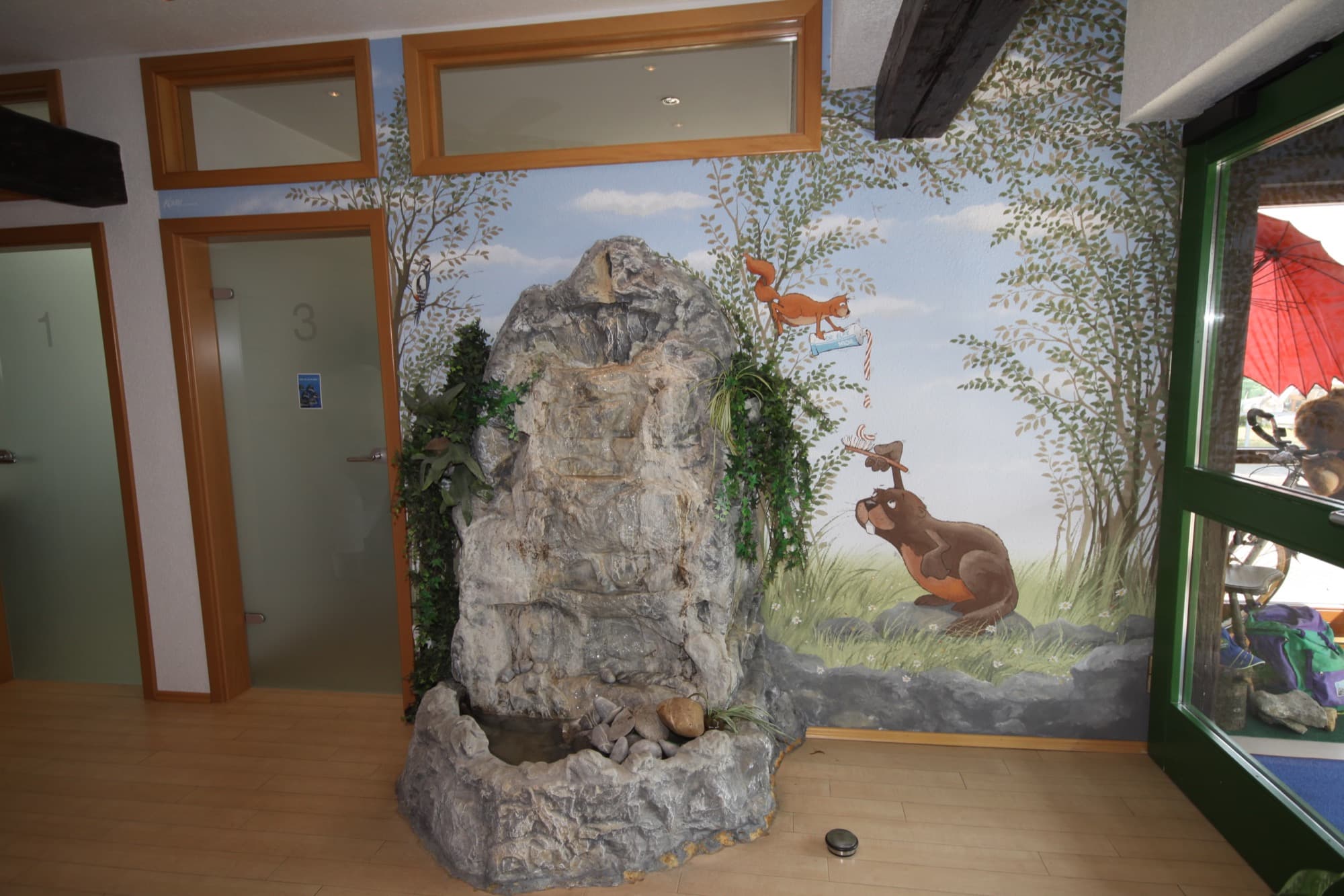 Eingangsbereich mit echtem Steinbrunnen und handgemaltem Wandbild